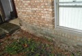 What causes brick stain or discoloration near the ground?