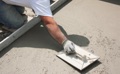 Where is a 6-mil polyethylene (Visqueen) vapor retarder not required under a concrete floor slab on grade?