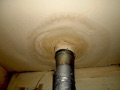 Why is there a stain in the ceiling around the exhaust pipe (flue) above the gas furnace?