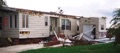 Why is it a dangerous mistake to attach a carport, porch, or room addition directly to the roof of a mobile home?
