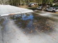 What causes ponding (standing water) on a flat roof?