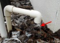 What is the small pipe on the side of the house that is dripping water?