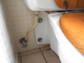 What are the pros and cons of a wall-mounted toilet?